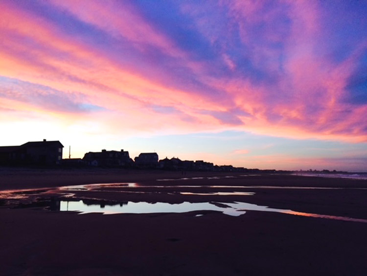 Beautiful clouds take in the light from the sunrise on a fall beach morning.